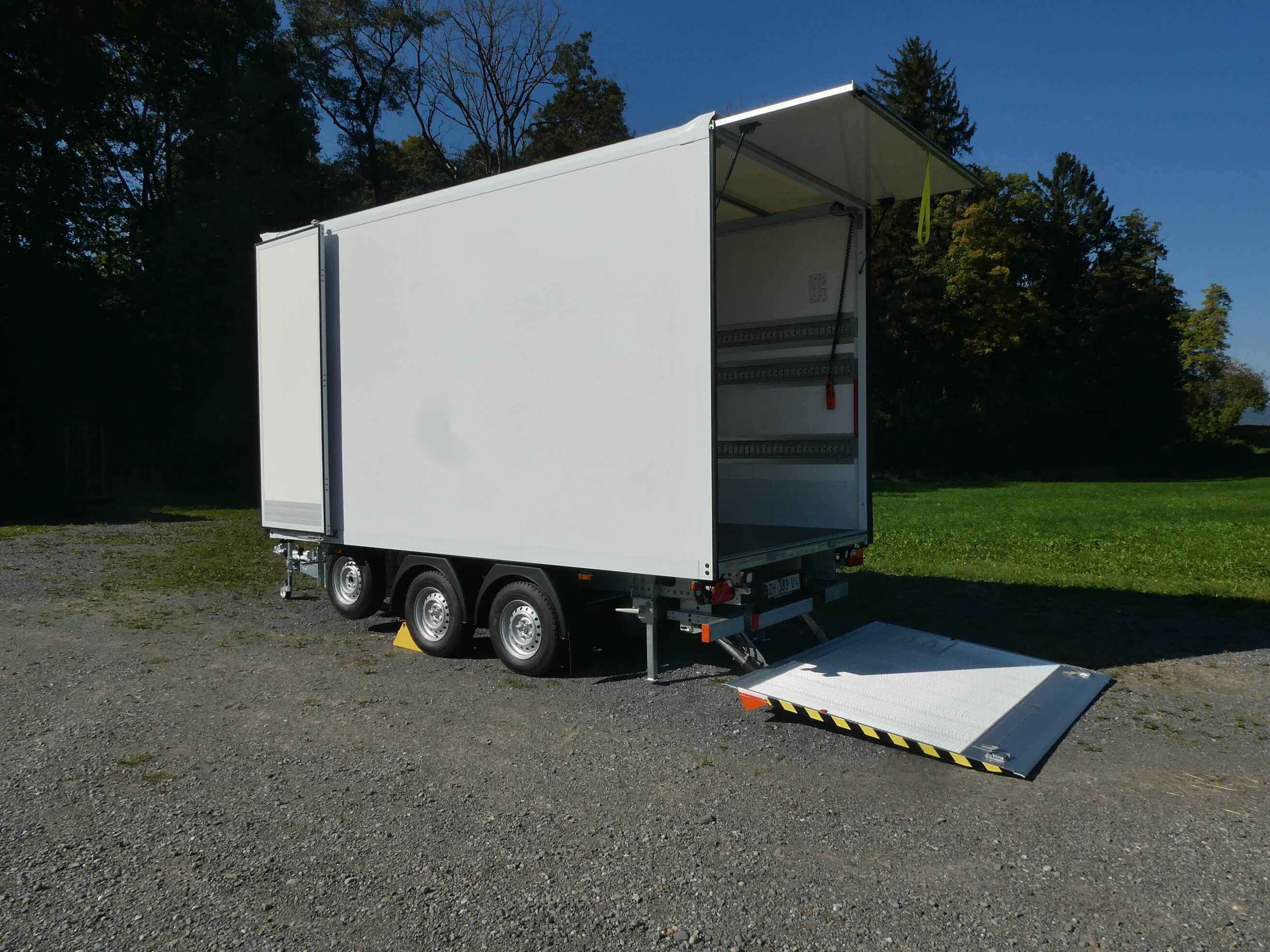 Neuer Baldinger Serien Box Trailer vorne und hinten geöffnet mit abgesenkter Hebebühne