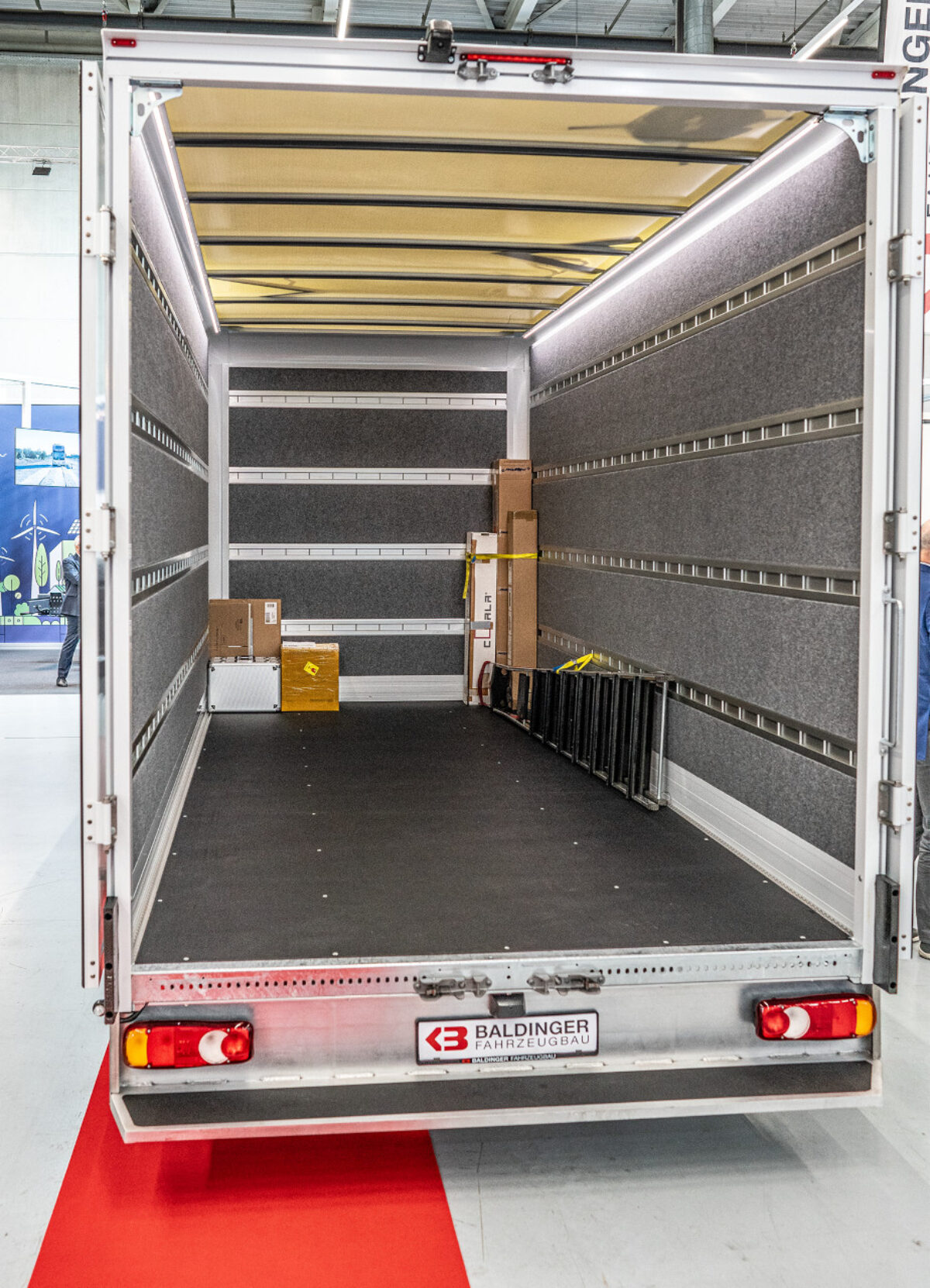 Heckansicht der geöffneten Hecktüren auf die Ladefläche der Baldinger Serien Box mit Filz Innenausbau